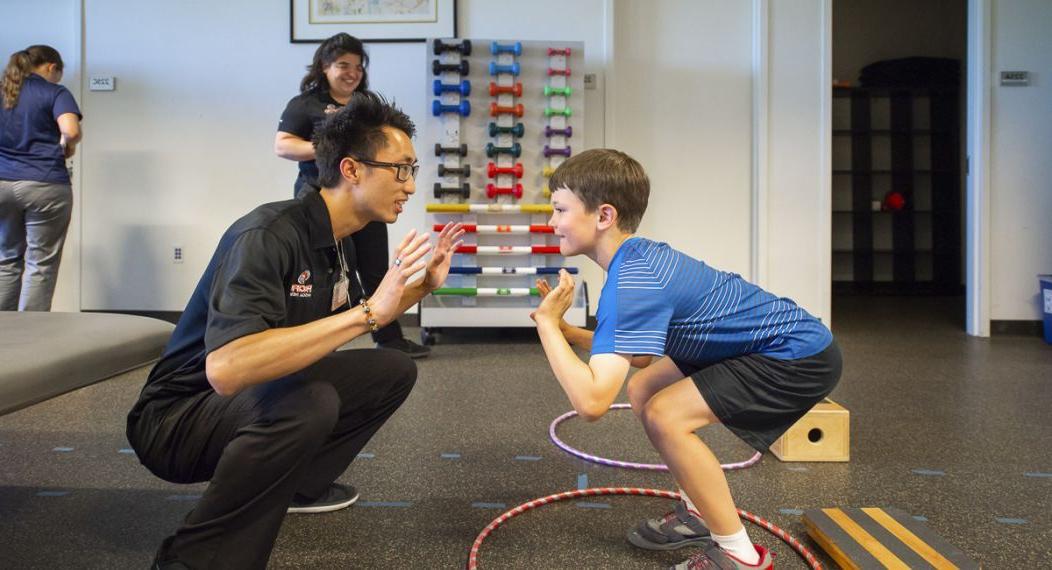 a physical therapy student works with a child during a clinic